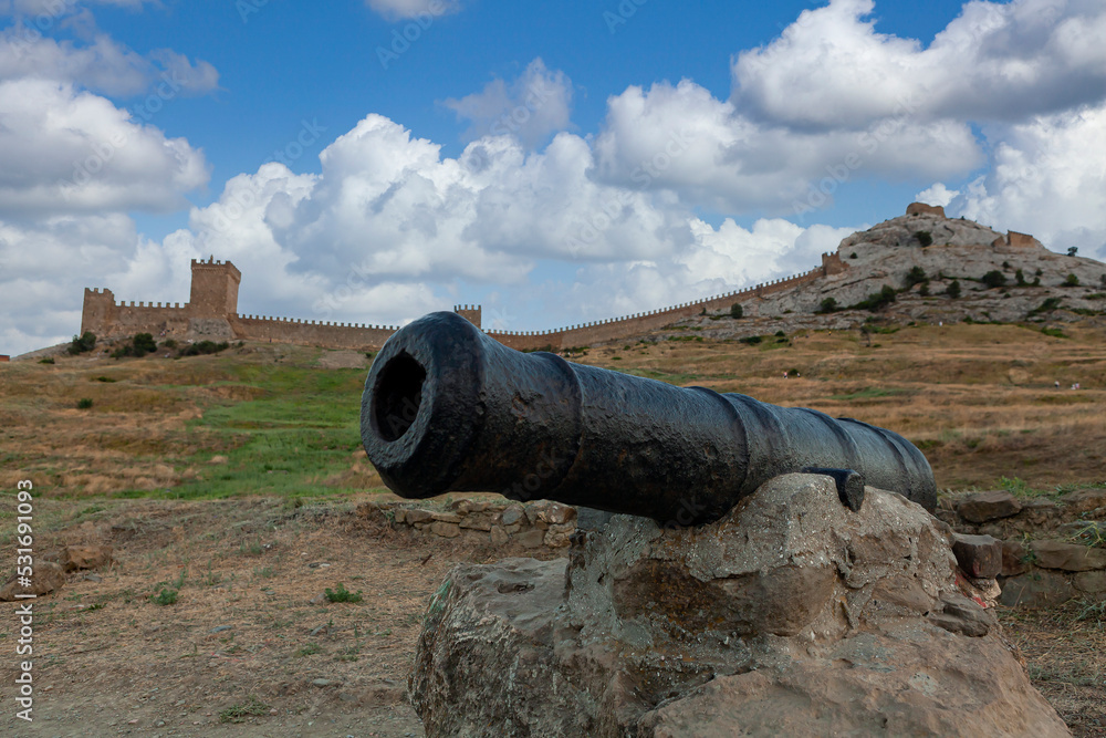 Ancient cannon on the background of the Genoese fortress in Sudak Crimea
