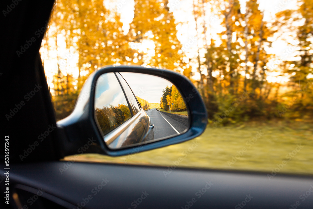 Autumn landscape from the car. The road going back in the rearview mirror. Front view.