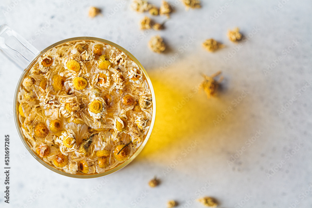 Chamomile tea with flowers in a glass cup. Healthy herbal drink, natural antiseptic. Chamomile tea with flowers in a glass cup. Healthy herbal drink, natural antiseptic.