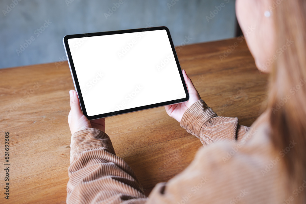 Mockup image of a woman holding digital tablet with blank white desktop screen Mockup image of a woman holding digital tablet with blank white desktop screen