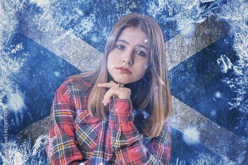Teenage girl on frozen background with flag of Scotland. Concept of crisis in Europe in winter. Energy crisis. photo
