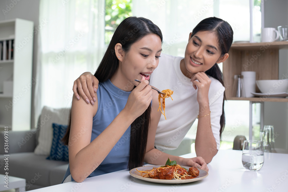 Young beautiful Asian lesbian couple lifestyle living concept. Happy LGBT couple having breakfast together in the kitchen. Young beautiful Asian lesbian couple lifestyle living concept. Happy LGBT couple having breakfast together in the kitchen.