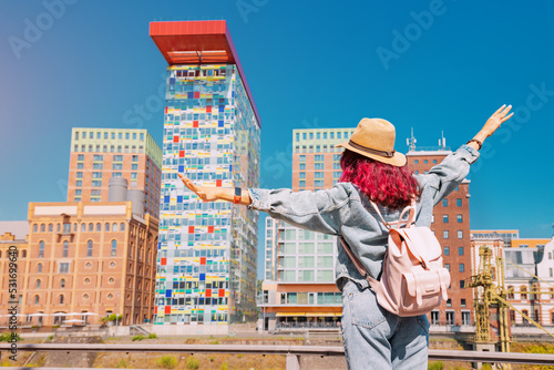 A girl traveler enjoys a beautiful view in the Media Bay during a tourist trip or a student education in Dusseldorf
