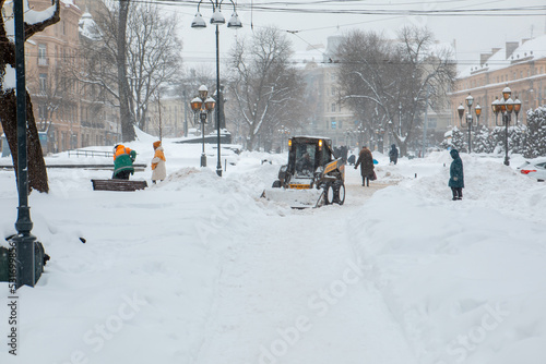 tractor is cleaning city streets after snow storm © phpetrunina14