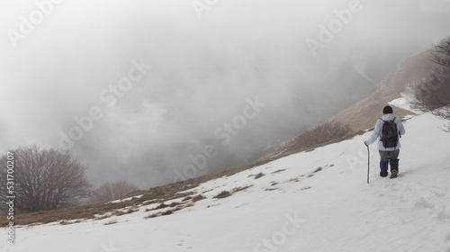 Hiker on the summit of a mountain with snow
