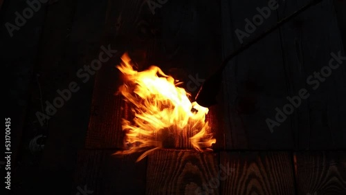 The gas burner burns with a blue flame. A bright golden fire burns the wood and it turns black. Video HD