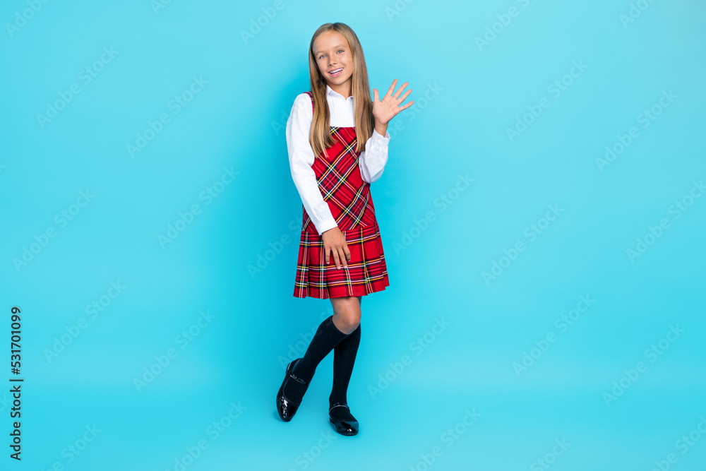 Full body size photo of little cute nice schoolgirl wear uniform showing five fingers hello world isolated on blue color background Full body size photo of little cute nice schoolgirl wear uniform showing five fingers hello world isolated on blue color background