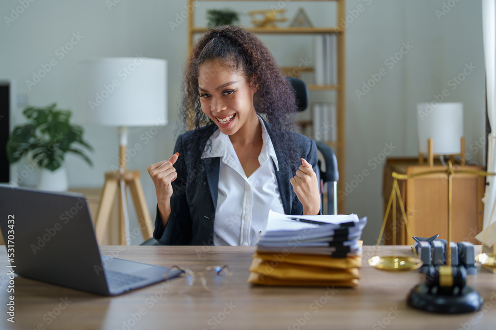 female African Americans lawyer showing joy while using a computer female African Americans lawyer showing joy while using a computer