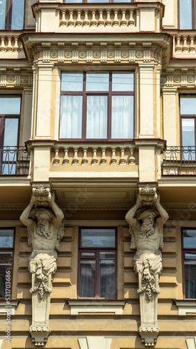 Statues or bas-reliefs of Atlanteans on Profitable House of Ratkov-Rozhnov on embankment of Griboyedov Canal, St. Petersburg, Russia. Vertical image