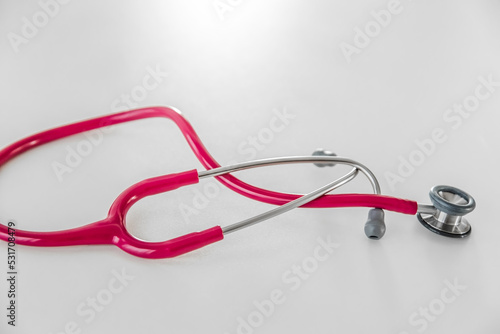 Różowy stetoskop na białym tle