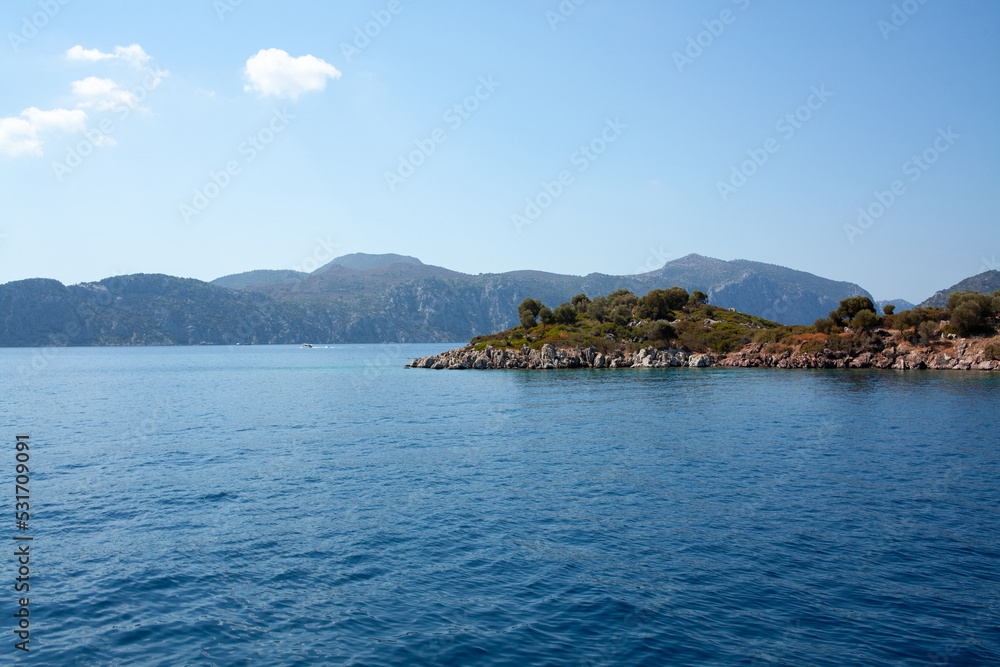 island and cliffs in Mediterranean sea or Aegean Sea with deep blue color water. turquoise colored water on island coast.