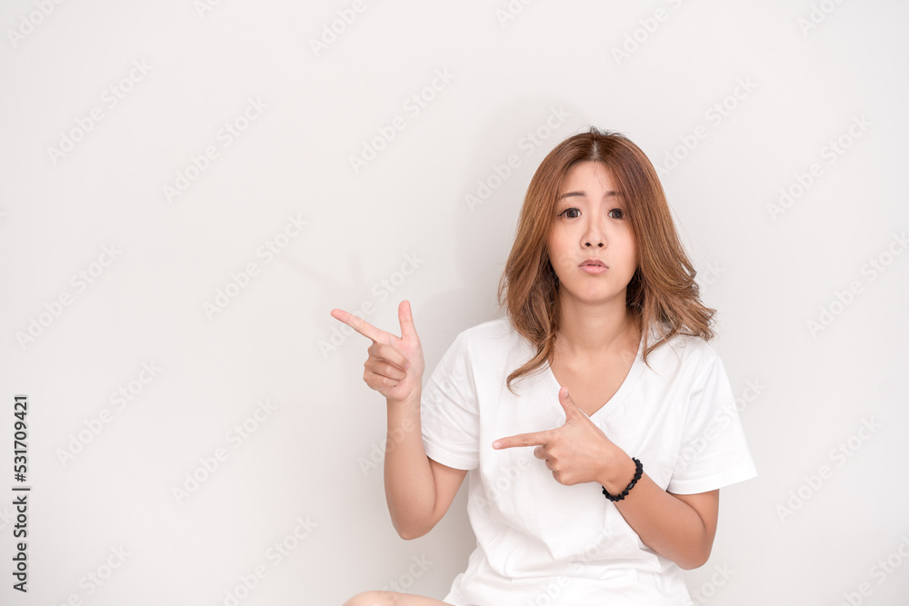 Photo of happy young woman standing isolated over white wall background. Looking camera showing copyspace pointing. Photo of happy young woman standing isolated over white wall background. Looking camera showing copyspace pointing.
