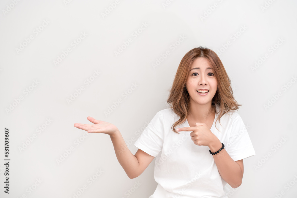 Photo of happy young woman standing isolated over white wall background. Looking camera showing copyspace pointing. Photo of happy young woman standing isolated over white wall background. Looking camera showing copyspace pointing.