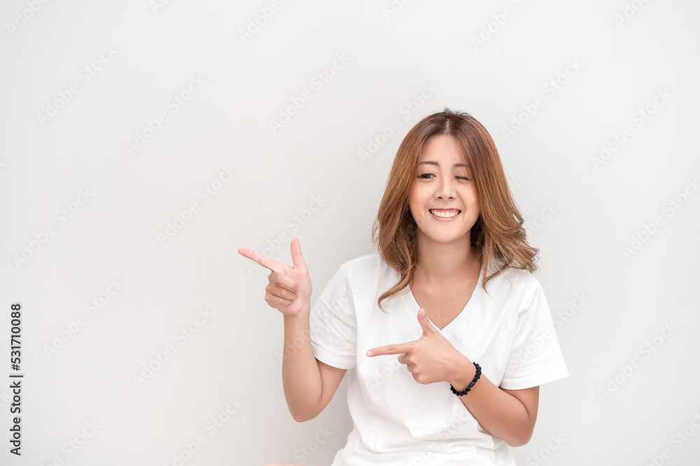 Photo of happy young woman standing isolated over white wall background. Looking camera showing copyspace pointing. Photo of happy young woman standing isolated over white wall background. Looking camera showing copyspace pointing.