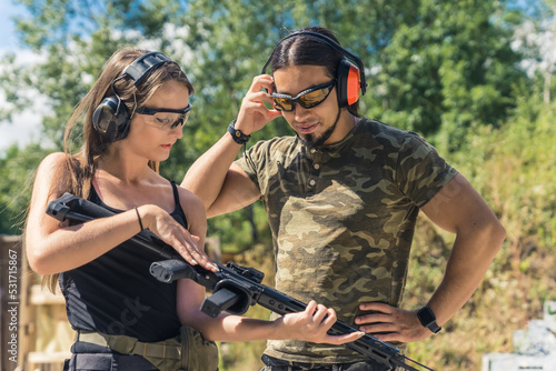 medium shot of a young and skinny woman with an instructor at the shooting range, outdoors. High quality photo