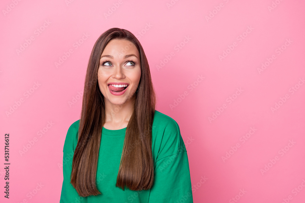 Photo of cheerful good mood girl long hairstyle wear green t-shirt look empty space tongue teeth isolated on pink color background Photo of cheerful good mood girl long hairstyle wear green t-shirt look empty space tongue teeth isolated on pink color background