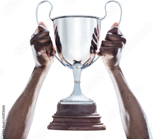 Image of hands of african american man holding up silver trophy cup