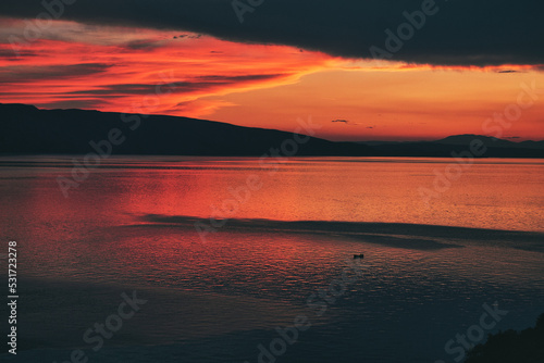 red sunset over the sea with mountains