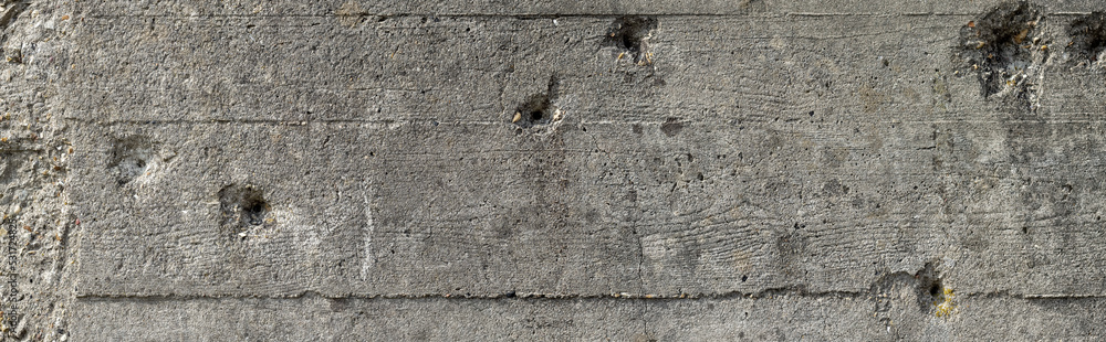 Wide concrete wall with bullet holes background. Bullet holes on a gray concrete wall of a second world war bunker in Normandy - obrazy, fototapety, plakaty 
