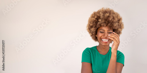 Fotografiet Happy attractive young dark-skinned woman in green t-shirt and afro hairstyle laughing with her eyes closed