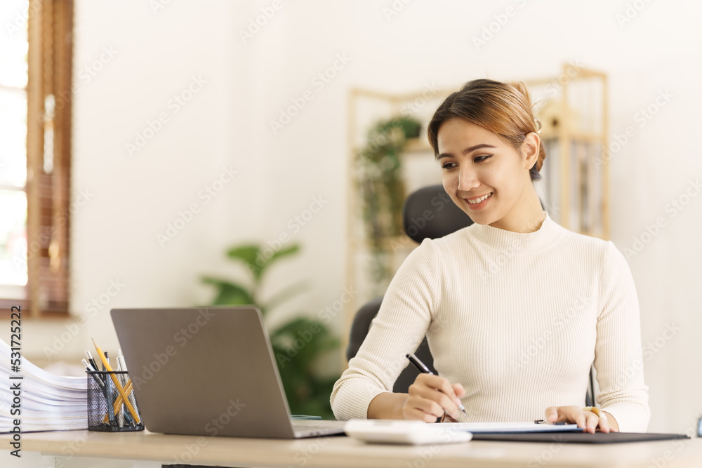 Asian thai businesswoman using laptop at working desk in modern office, busy job but feeling happy. Asian thai businesswoman using laptop at working desk in modern office, busy job but feeling happy.