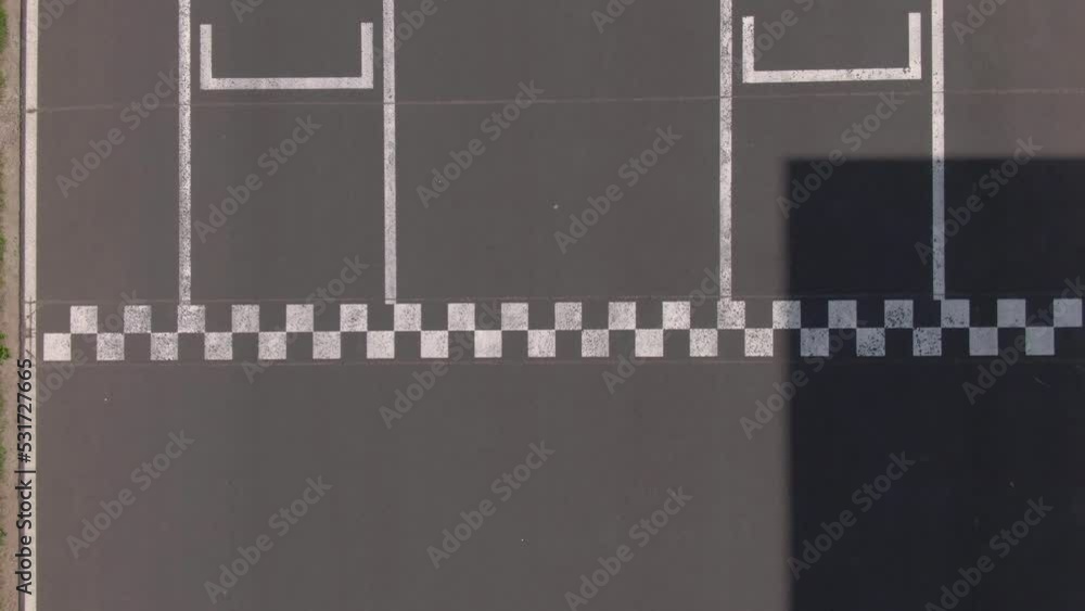 Kart racer crossing Checkered finish line, top down aerial view