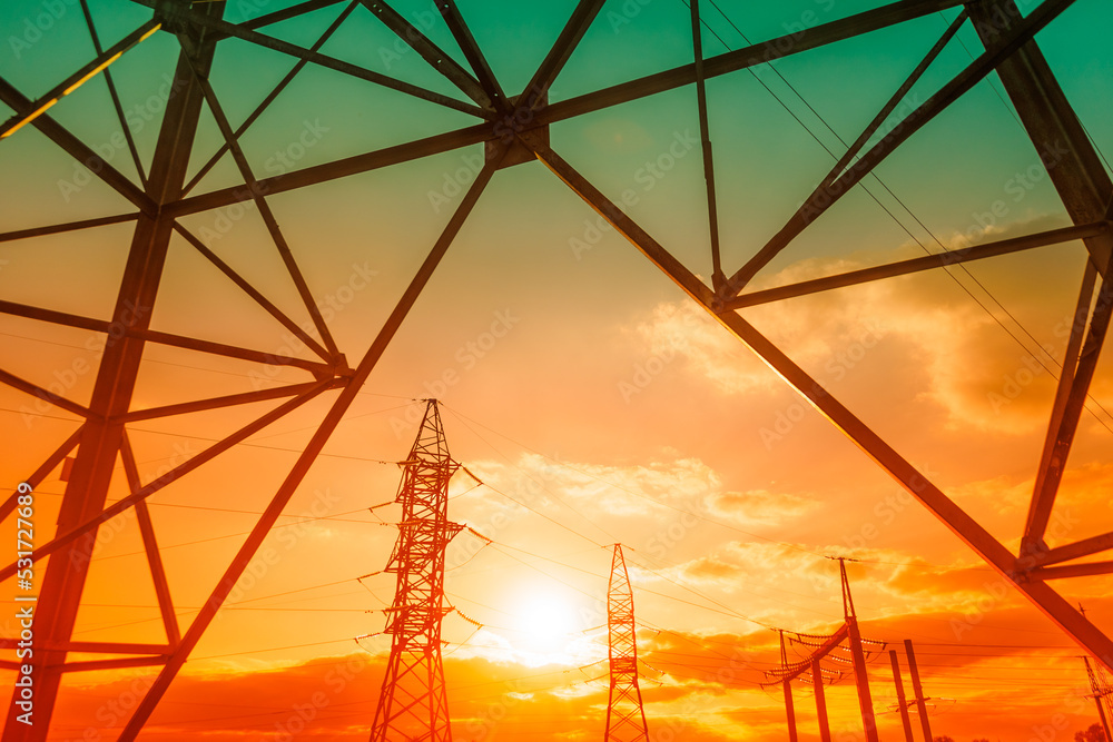 high voltage post and power lines at sunset electricity pylons in a row ...