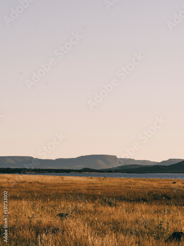 sunset by a dam with golden brown grass