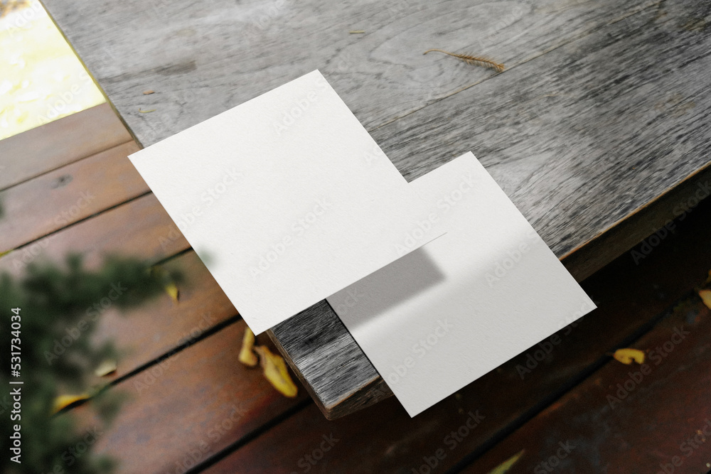Clean minimal square flyer mockup on top wooden with plant Clean minimal square flyer mockup on top wooden with plant