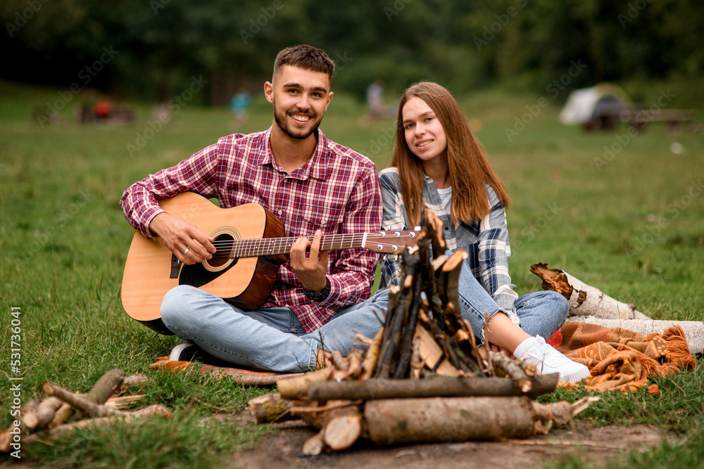 happy couple with guitar spending time together at park. Love story.