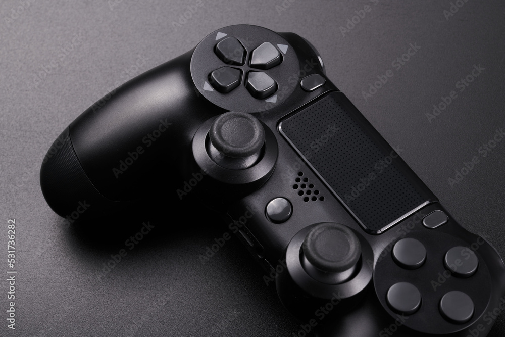 Black video game controller, joystick for game console isolated on black background. Gamer control device close-up Black video game controller, joystick for game console isolated on black background. Gamer control device close-up
