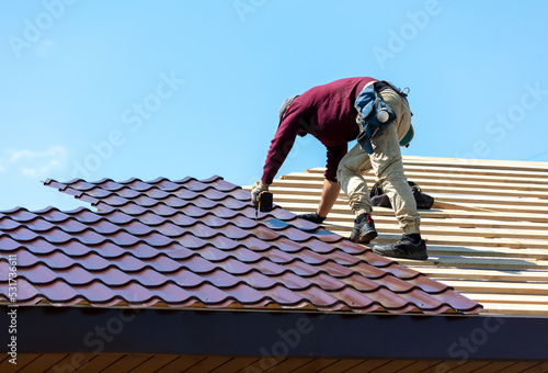 Wallpaper Mural Workers install metal roofing on the wooden roof of a house. Torontodigital.ca