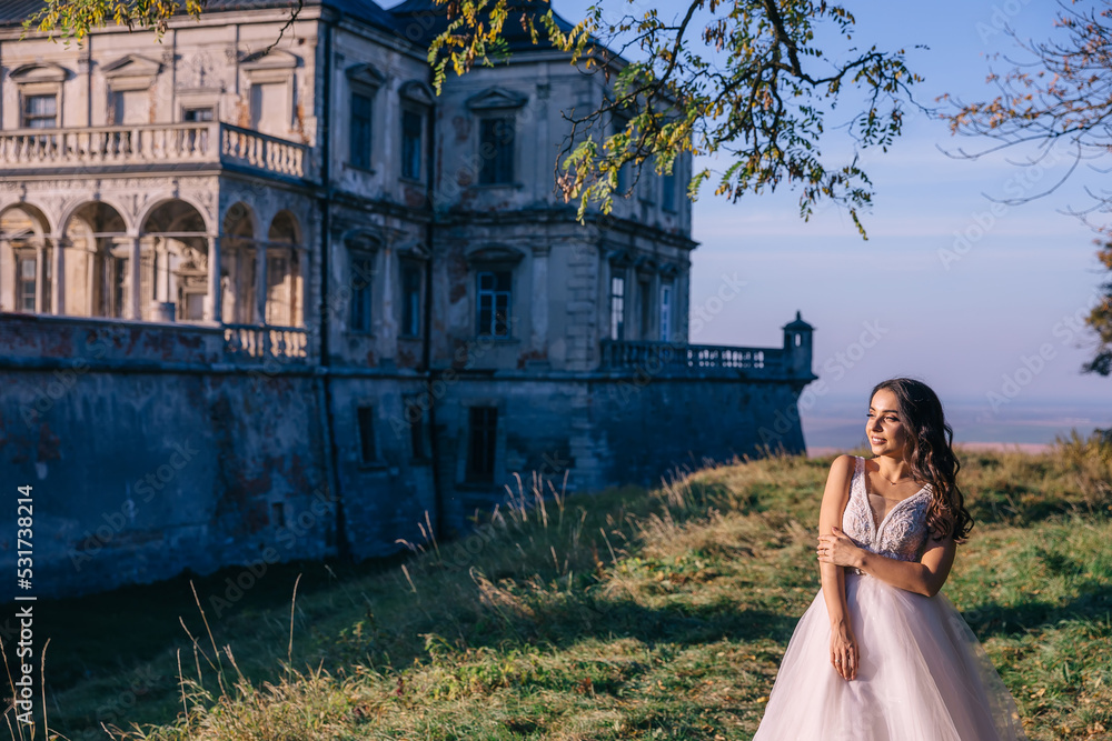 beautiful bride in a white dress near the castle enjoying nature