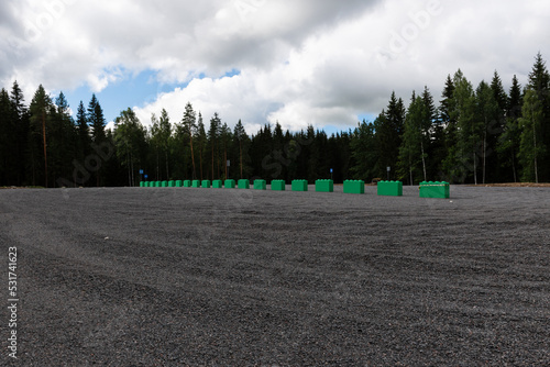 Empty gravel parking lot with a coniferous forest in the background