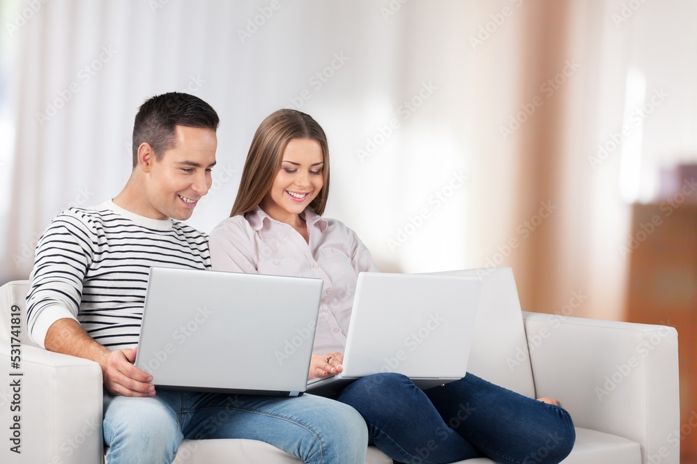 Fototapeta premium Happy couple relaxing on couch in home interior