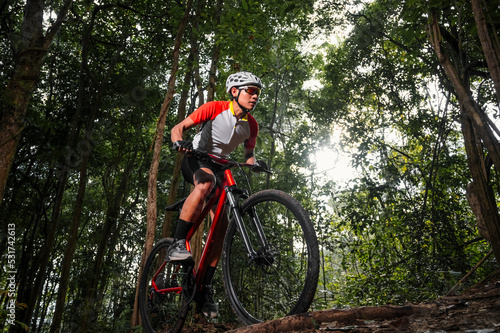 Mountain bikers ride MTB  mountain bike downhill to the extreme. Asian man rides MTB  mountain bike downhill in the wild to extremes. Extreme Sport and MTB  mountain bike downhill Concept.