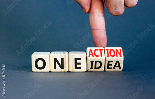 One idea and action symbol. Concept words One idea and One action on wooden cubes. Businessman hand. Beautiful grey table grey background. Business One idea and action concept. Copy space.