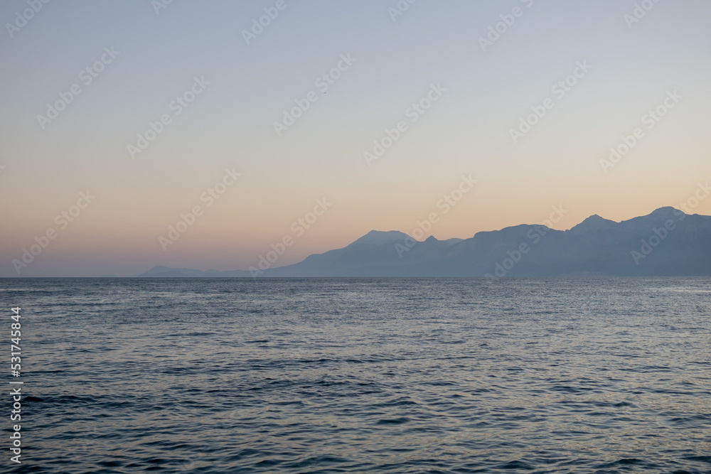 sea ​​against the backdrop of mountains at sunset.