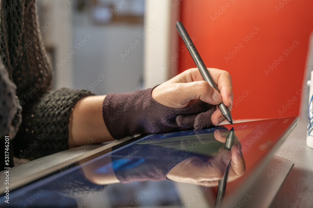 Foto de main en train de dessiner sur une tablette tactile avec un