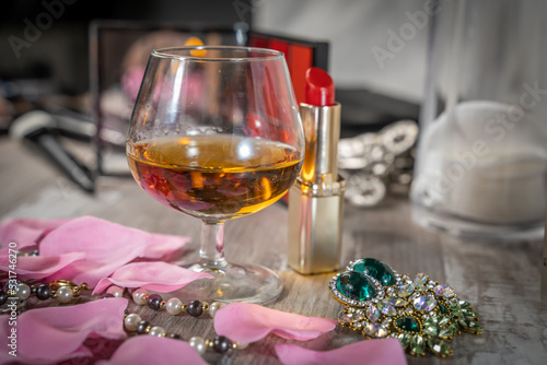 petit verre de bourbon sur une table de loge avec du maquillage et des bijoux photo
