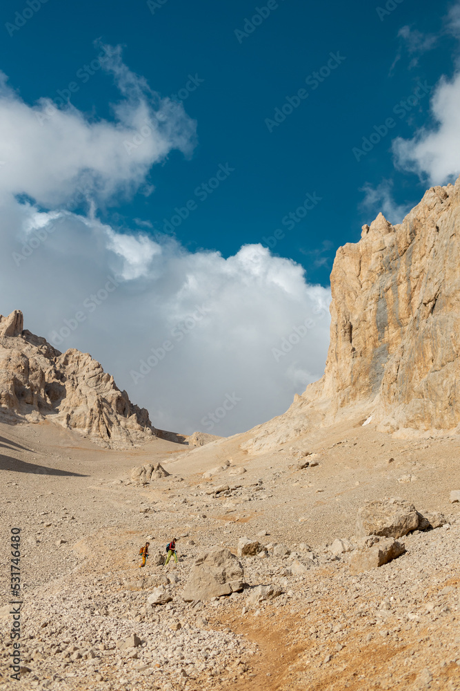 Two tourists with backpacks in the mountains. Tourists travel through the rocky mountains. Active rest in mountain hiking. Adventure in the mountains. . Two tourists with backpacks in the mountains. Tourists travel through the rocky mountains. Active rest in mountain hiking. Adventure in the mountains. .