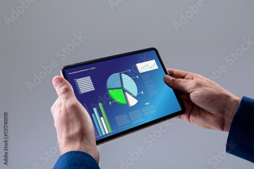 Cropped hands of cuacasian businessman holding digital tablet with infographic data