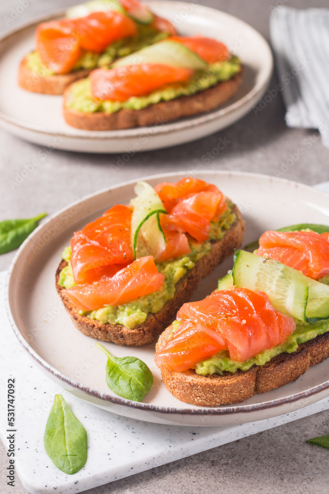Open sandwich with smoked and salted salmon for healthy breakfast. Trout and avocado on bruschetta toast. Open sandwich with smoked and salted salmon for healthy breakfast. Trout and avocado on bruschetta toast.