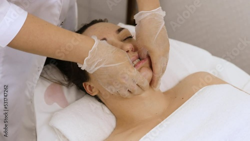 Woman receiving facial buccal massage in beauty salon.Beauty and skincare concept with a beautiful woman. Middle aged female relaxed with massage for facial lifting	 photo