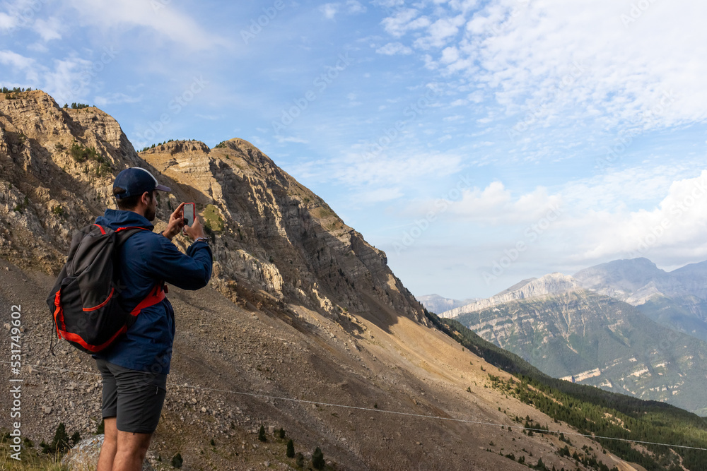 backpacker boy with smartphone in the mountains
