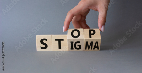 Stop and Stigma symbol. Concept words Stop and Stigma on wooden cubes. Beautiful grey background. Businessman hand. Business and Stop and Stigma concept. Copy space.