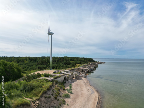 Aerial view of Liepaja Northern Forts  old abandoned fortifications at Baltic sea coast in Latvia. Large wind turbine