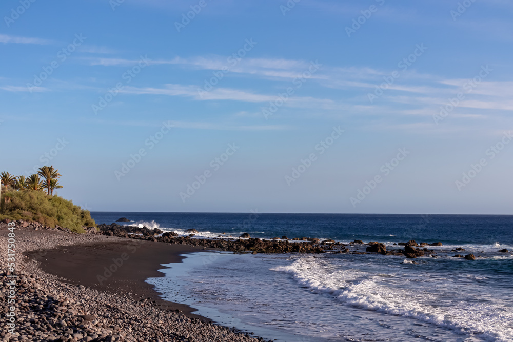 Panoramic view on the beach Playa Valle Gran Rey seen from Promenade de Playa de La Calera in Valle Gran Rey on La Gomera, Canary Islands, Spain, Europe. Pebble beach and dark volcanic sand beach