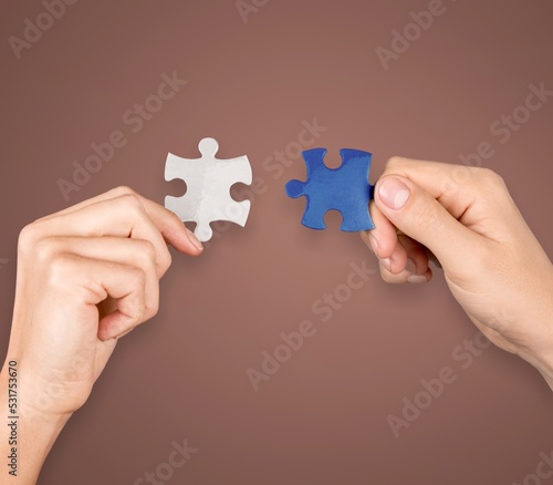 Human hands hold a puzzle piece for teamwork concept