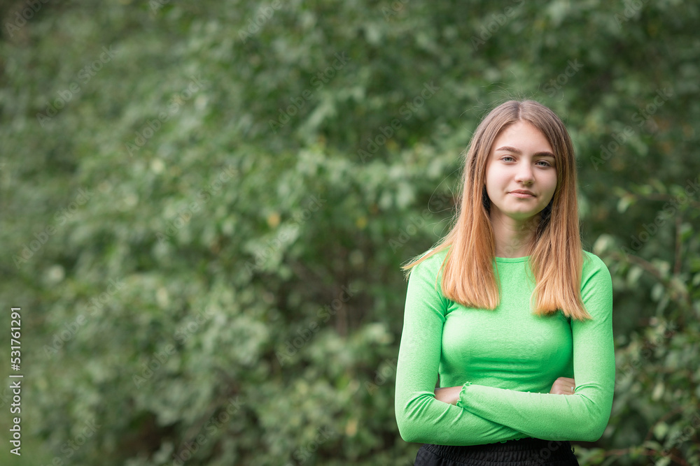 Portrait of a young beautiful girl in a green blouse and black parka pants. Portrait of a young beautiful girl in a green blouse and black parka pants.